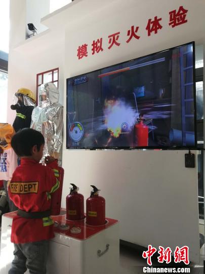 圖為一名小學(xué)生體驗(yàn)?zāi)M滅火 劉鵬 攝