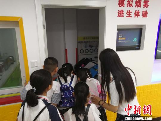 圖為學(xué)生們模擬練習(xí)煙霧逃生 劉鵬 攝